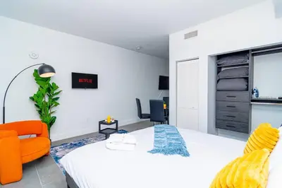 a bedroom with a bed and an orange chair at Luxury Studio Suite with King Bed Near Brickell & Marlins Park in Miami