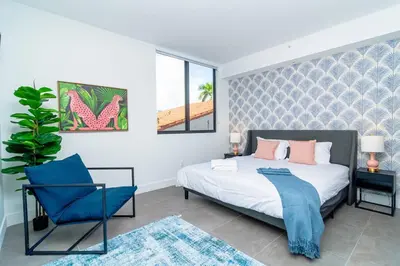 a bedroom with a bed and a blue chair at Modern 1BR Suite with King Bed Near Brickell, Downtown & Wynwood in Miami