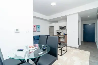 a dining room and living room with a glass table at Modern 1BR Suite with King Bed Near Brickell, Downtown & Wynwood in Miami