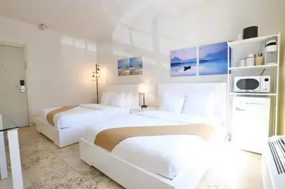 two beds in a hotel room with white walls at Ocean Drive Suite in South Beach Family & Pet Friendly in Miami Beach