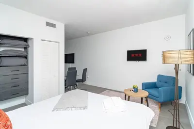 a bedroom with a bed and a blue chair at Prime Miami Retreat with King Bed Near Brickell & Marlins Park in Miami