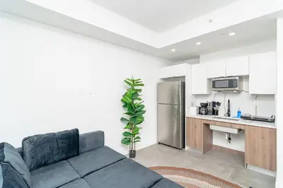 a living room with a couch and a kitchen at Prime Miami Retreat with King Bed Near Brickell & Marlins Park in Miami