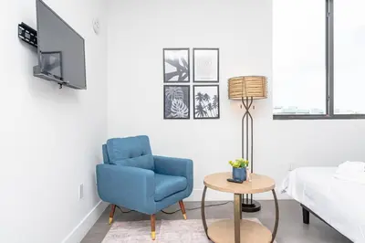 a bedroom with a blue chair and a table at Prime Miami Retreat with King Bed Near Brickell & Marlins Park in Miami