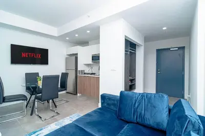 a living room with a blue couch and a table at Stylish Studio Miami Suite Oasis Near Calle Ocho & Brickell in Miami