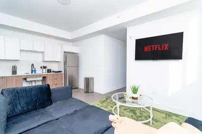 a living room with a blue couch and a kitchen at Stylish 2BR Miami Retreat Mins to Wynwood and Brickell in Miami