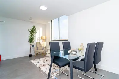 a dining room with a glass table and chairs at Stylish 2BR Miami Retreat Mins to Wynwood and Brickell in Miami