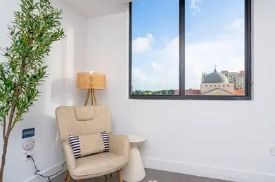 a living room with a chair and a window at Stylish 2BR Miami Retreat Mins to Wynwood and Brickell in Miami