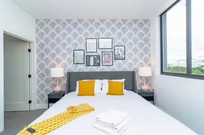 a bedroom with a large white bed with yellow pillows at Miami City Escape 2BR Suite Near Brickell & The Beach Sleeps 6 Guests in Miami