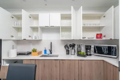 a kitchen with white cabinets and a counter top at Miami City Escape 2BR Suite Near Brickell & The Beach Sleeps 6 Guests in Miami