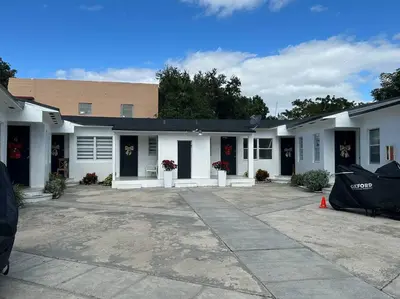 a large white building with black doors and flowers at Villa Clara VIP-Little Havana in Miami