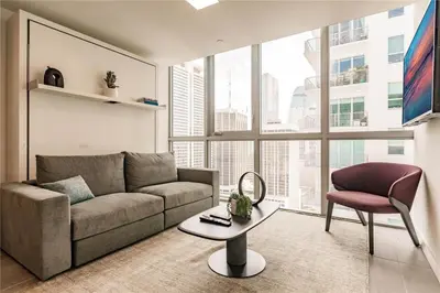 a living room with a couch and a table and a chair at Exclusive Condo w Beautiful City Views and Full Amenities! in Miami