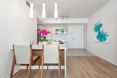 a kitchen and dining room with a table and chairs at Modern Resort with Amazing Pool in Hallandale Beach