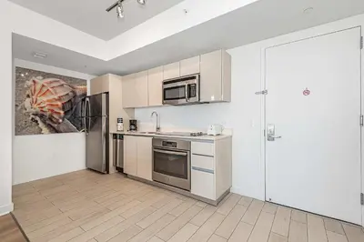 a kitchen with a sink and a refrigerator at Modern Resort with Amazing Pool in Hallandale Beach