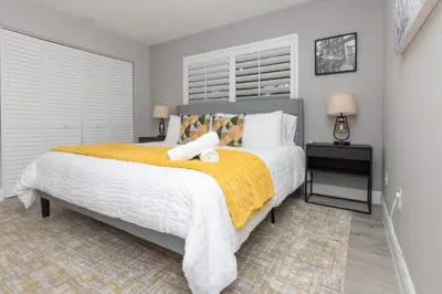 a bedroom with a large bed with a yellow blanket at Heated pool - 5min Coral Gables - Family Vacation in Miami