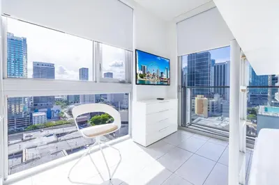 a white chair in a room with large windows at Charming 2 BR Downtown Miami 2106 Free Parking in Miami