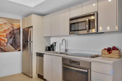 a kitchen with white cabinets and a microwave at Spectacular Near Beach - 2 BR Apartment in Hallandale Beach