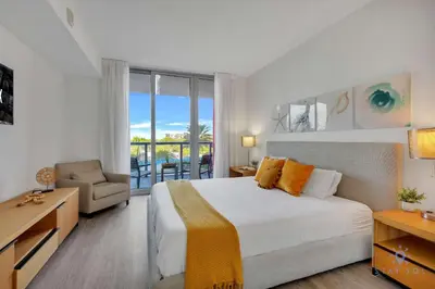 a bedroom with a large bed and a balcony at Great views Apartment with Pool-Balcony-Gym in Hallandale Beach