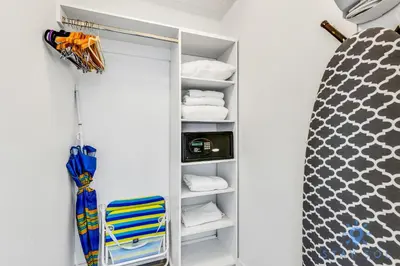 a walk in closet with towels and a chair at Amazing Apartment with Balcony & Pool in Hallandale Beach