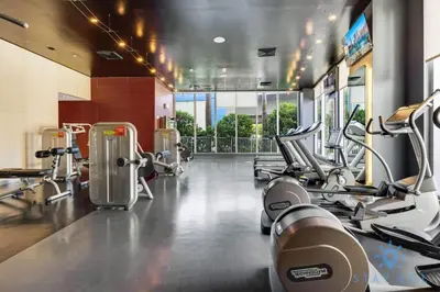 a gym with several treadmills and machines at Amazing Apartment with Balcony & Pool in Hallandale Beach