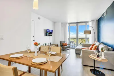 a living room with a dining table and a couch at Amazing Apartment with Balcony & Pool in Hallandale Beach