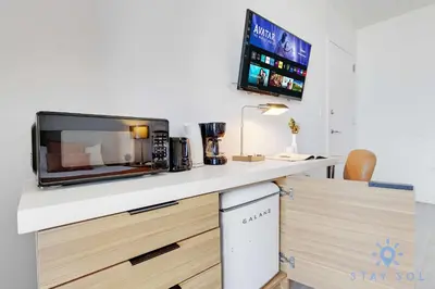 a kitchen with a microwave and a tv on a counter at Amazing Balcony Near Beach in Hallandale Beach