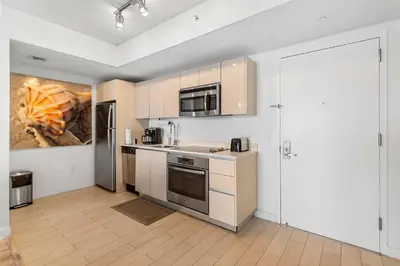 a kitchen with white cabinets and stainless steel appliances at Deluxe Apartment with Balcony Gym & Pool in Hallandale Beach