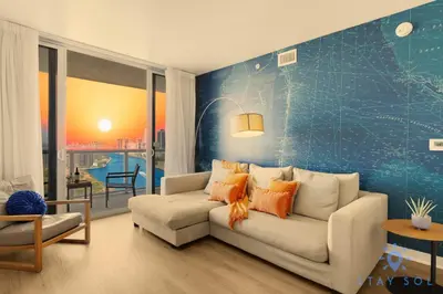 a living room with a white couch and a blue wall at Urban Apartment Balcony & Pool in Hallandale Beach