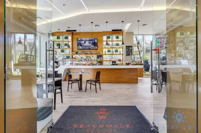 a restaurant with a counter and tables and chairs at Stylish Apartment Near Beach in Hallandale Beach