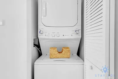 a washer and dryer with a basket on top of it at Modern Resort -Balcony Views & Pool in Hallandale Beach