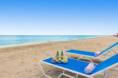 a picnic table on the beach with beers and snacks at Modern Resort -Balcony Views & Pool in Hallandale Beach