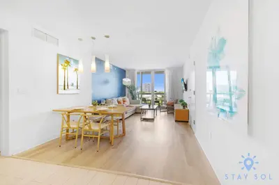 a dining room and living room with a table and chairs at 1 BR Modern Resort Balcony Gym & Amazing Pool in Hallandale Beach