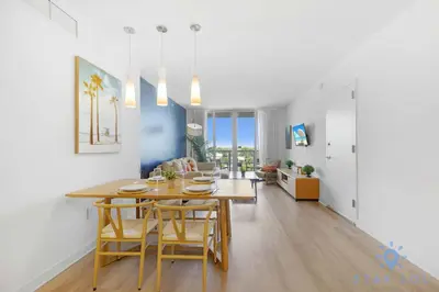 a dining room and living room with a table and chairs at 1 BR Modern Resort Balcony Gym & Amazing Pool in Hallandale Beach