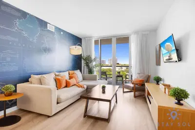 a living room with a white couch and a blue wall at 1 BR Modern Resort Balcony Gym & Amazing Pool in Hallandale Beach