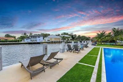 a row of chairs sitting next to a swimming pool at Coral Shores Waterfront Heated Pool Hosts 14! in Fort Lauderdale