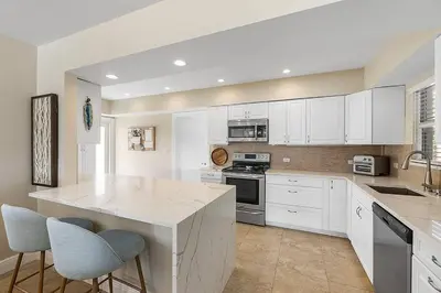 a kitchen with white cabinets and a white counter top at Coral Shores Waterfront Heated Pool Hosts 14! in Fort Lauderdale