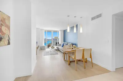 a white living room with a table and a couch at Stylish Apartment 2BD 2BTH in Hallandale Beach