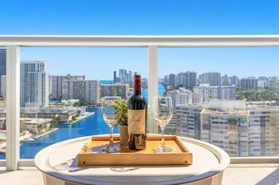 a table with two glasses and a bottle of wine at Stylish Apartment 2BD 2BTH in Hallandale Beach
