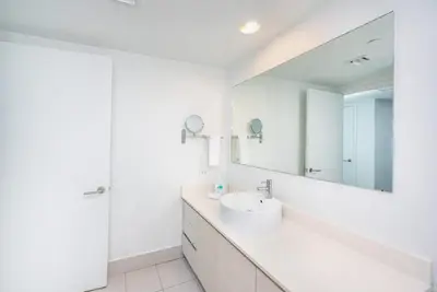 a white bathroom with a sink and a mirror at 2 Bed & 2 Bath at Beachwalk With Pool Gym on 16fl in Hallandale Beach
