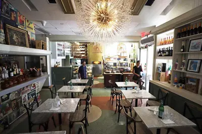 a restaurant with tables and chairs and a chandelier at Art Deco Suite Steps from Beach in South of Fifth in Miami Beach