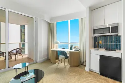 a living room with a kitchen and a table with chairs at Fontainebleau Hotel Junior Suite in Miami Beach