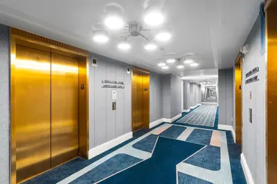 a hallway with doors and carpeted floors in a building at Fontainebleau Hotel Junior Suite in Miami Beach