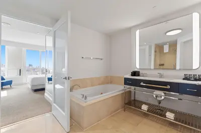a bathroom with a tub and a sink and a mirror at Fontainebleau Hotel One Bedroom Suite in Miami Beach