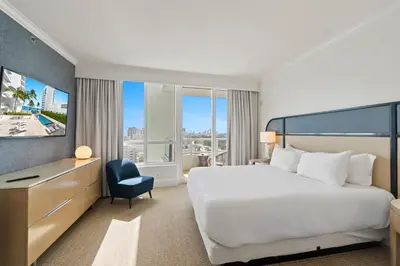 a hotel room with a large bed and a desk at Fontainebleau Hotel One Bedroom Suite in Miami Beach