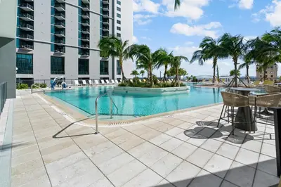 a swimming pool with palm trees in a building at NEW 28th Floor unit - Breathtaking Bay and Downtown Views in Miami
