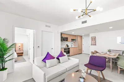 a living room with a white couch and purple pillows at NEW 28th Floor unit - Breathtaking Bay and Downtown Views in Miami