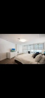 a bedroom with a large bed with a tv on it at Luxury - Ocean front - Free Parking - 3 Bed 2 Bath in Miami Beach