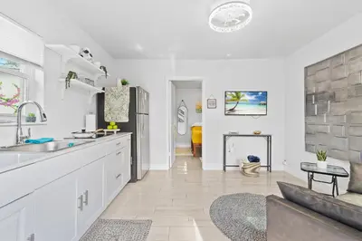 a kitchen with a sink and a living room with a couch at Cozy Casarita Cottage in Miami