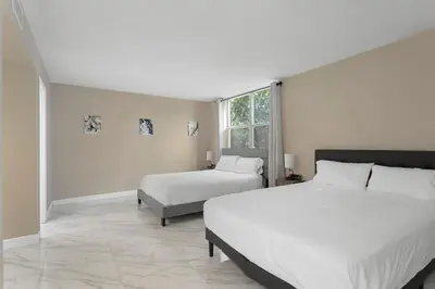 a bedroom with two beds and a window at Bay Harbor Sunset Apt 2A in Miami Beach