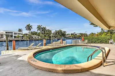a swimming pool with a view of the water at Bay Harbor Sunset Apt 2A in Miami Beach