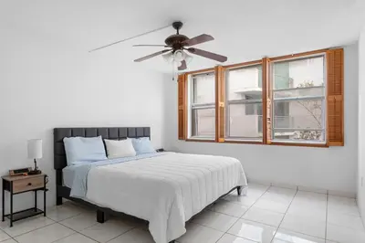 a bedroom with a bed and a ceiling fan at Bay Harbor Sunset Apt 2B in Miami Beach